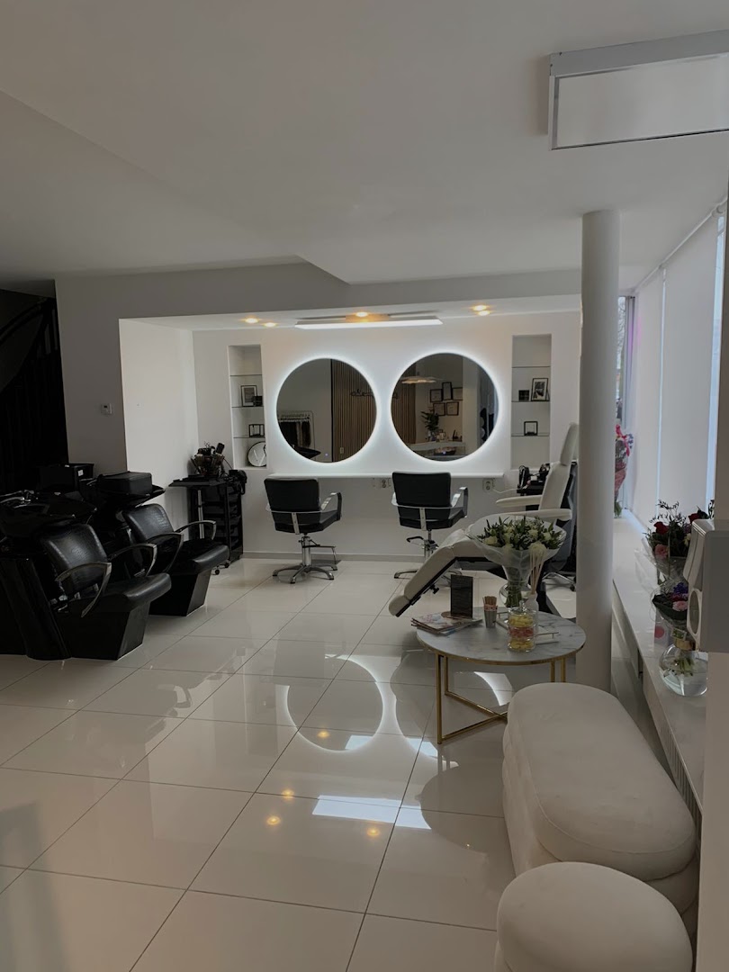 Modern salon-interieur van Kapsalon Chiman met ronde backlit spiegels, zwarte kappersstoelen en witte porseleinen vloer