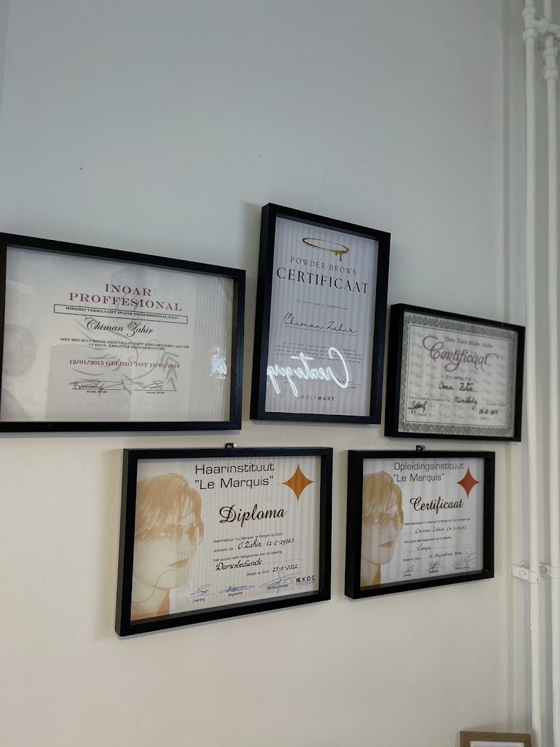 Vijf ingelijste diploma's en certificaten van Chiman Zahir aan de muur van de salon